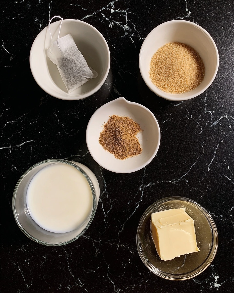 The image shows five small containers and a glass cup arranged on a black surface changed to white marbled texture. At the top left, there is a small white bowl with a tea bag inside, showing a little string hanging out. On the top right, another white bowl holds a small heap of light brown sugar grains. In the center, a shallow white dish contains a small pile of ground brown spice. At the bottom left, a clear glass cup is filled with white milk, and on the bottom right, a small clear glass contains a dollop of pale yellow butter or cream. The setup is simple and neat, showing raw ingredients before mixing photo taken with an iphone --ar 4:5 --v 7