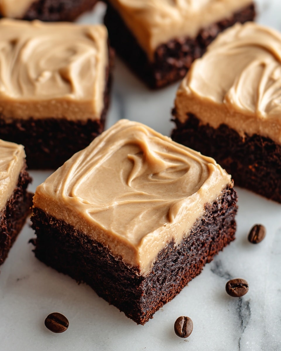 The image shows several square brownies with two clear layers. The bottom layer is thick, dark brown, and looks soft and moist. The top layer is smooth, light brown frosting with swirled patterns, spreading evenly over the brownies. The brownies are placed on a white marbled surface, with a few coffee beans scattered around for decoration. photo taken with an iphone --ar 4:5 --v 7