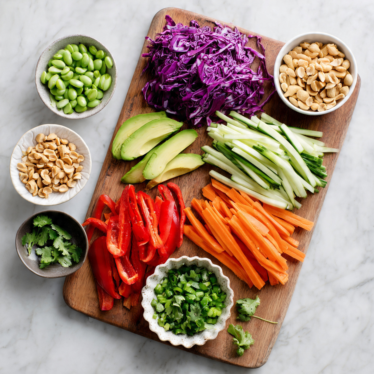 The image shows a wooden board on a white marbled surface, filled with neatly arranged fresh vegetables and nuts. From top right, there is a pile of thinly sliced purple cabbage with a rough texture, next to a heap of thin, pale green cucumber sticks in the middle. Below the cucumber are bright orange carrot sticks, also thin and long. To the right of the carrots, there are vibrant red bell pepper strips. In the bottom left corner, there are several slices of creamy green avocado arranged in a curve. On the bottom right of the board, a white speckled bowl holds fresh, bright green chopped cilantro. Above the avocado, a small white scalloped bowl is filled with chopped light brown peanuts. Near the top left corner of the board, a small white bowl contains green edamame, and just below it, there is a dark bowl filled with chopped light green scallions. The whole setting is clean and simple, with the colors of the veggies standing out against the white marbled background. photo taken with an iphone --ar 4:5 --v 7